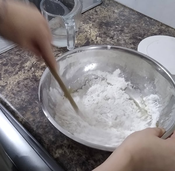 Mixing Neapolitan pizza dough with spoon