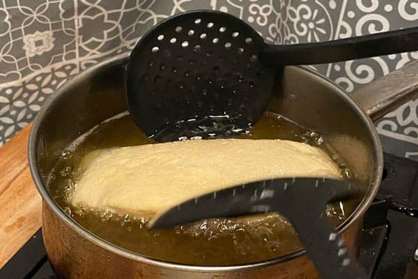 Pizza dough being fried