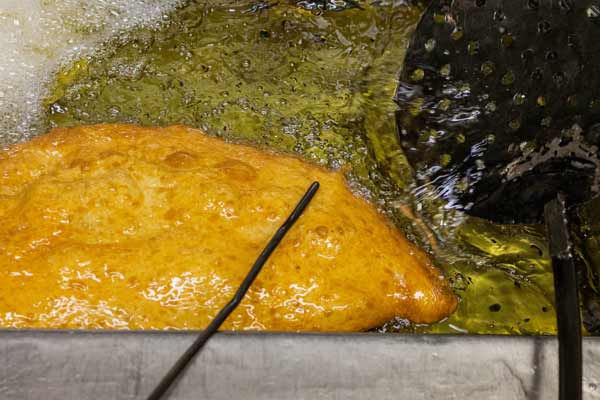 Pizza being cooked in a pizzeria using a deep fat frier